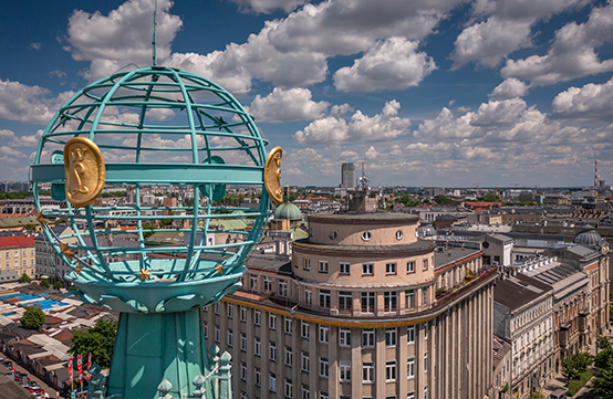 Sfera armilarna wieńcząca wieżę kamienicy Pod Globusem, w tle panorama Krakowa.