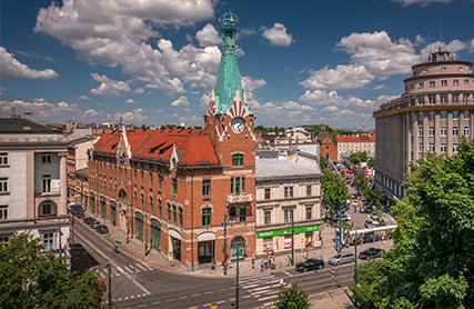 Widok kamienicy Pod Globusem z poziomu ulicy, z charakterystyczną wieżą w tle.